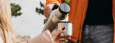 Mand der haelder vand ud af en staal termokande