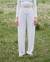 Pige klaedt i hvide zenith bukser paa en maelkeboettemark