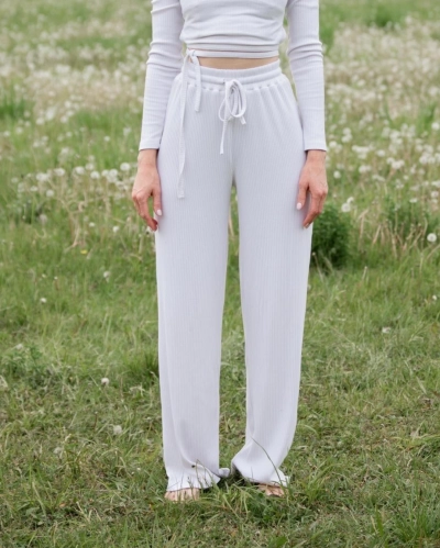 Pige klaedt i hvide zenith bukser paa en maelkeboettemark