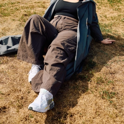 Person i komfortable natur bukser sidder paa graesunderlag