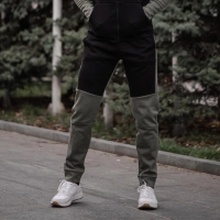 Person i letvaegts stibukser staar paa asfaltvej