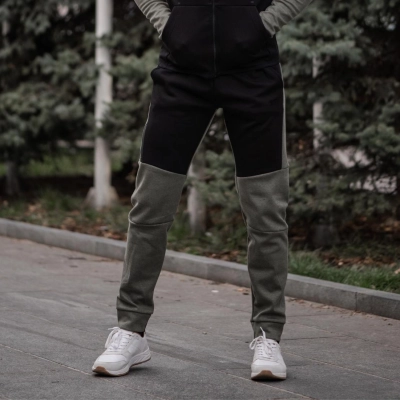 Person i letvaegts stibukser staar paa asfaltvej