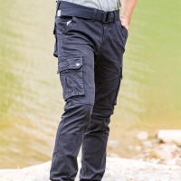 Person i eventyrbukser med lommer staar udendoers