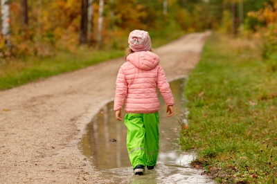 Barn i vandtaette flod bukser gaar paa sti med vandpytter