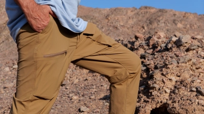 Person i packable nomad bukser med haanden i lommen i klippelandskab