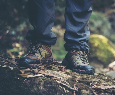 Naerbillede af vandrestovler paa mosdaekket underlag i naturen