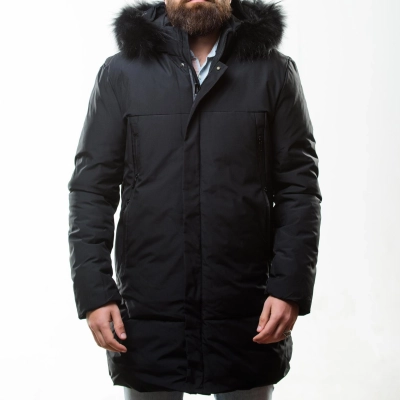 Mand med skaeg i morkeblaa stjernekigger parka med pelsforet haette