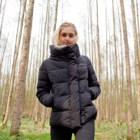 Kvinde med blond haar i sort baalvarme dunjakke i skov