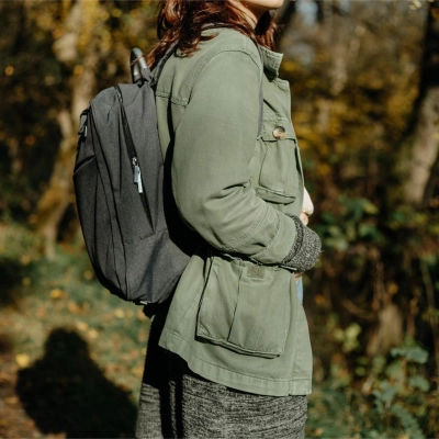 Person med ryggsaek og Flux Terra Jakke i efteraarslandskab