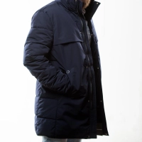 Mand i morkeblaa stroemmfanger vandtaet jakke med haenderne i lommen