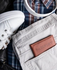 Detalje af et par hvide denimbukser oven på en ternet skjorte med et par sneakers ved siden af.