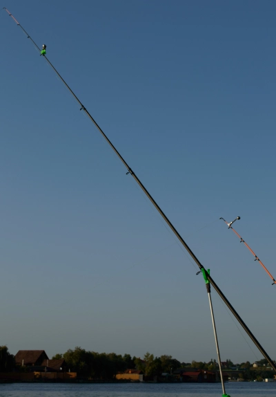 Fiskestang af kulfiber mod blaa himmel og flod